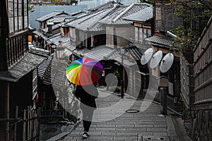 Man walking in umbrella area in Higashiyama Known as Ninen-zaka, it is Kyoto`s distinctive street, especially between