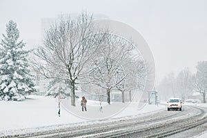 Man walking under snow. Heavy snowfall and snowstorm in Toronto, Ontario, Canada. Snow blizzard and bad weather winter condition.