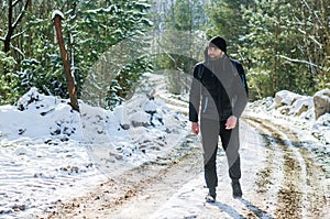 Man walking in winter snowy forest