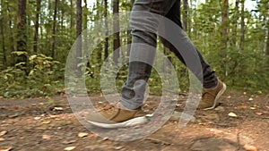 Man Walks along the Forest. Tourist in Boots Going along the Road on the Background a Beautiful Landscape. Travel