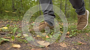 Man Walks along the Forest. Tourist in Boots Going along the Road on the Background a Beautiful Landscape. Travel