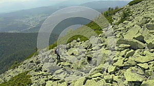 A man walks along a mountain slope covered with giant stones. Solo tourism.