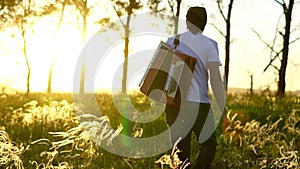 A man walks on a field at sunset