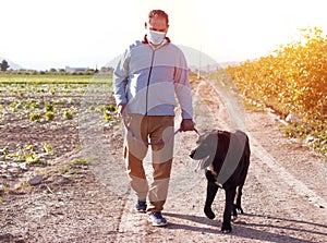 A man walks with his dog outdoors after Spain imposed a lockdown to slow down the spread of the coronavirus disease photo