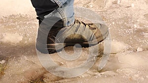 Man walks on ice with winter boots in the forest. Human footprints. Sport