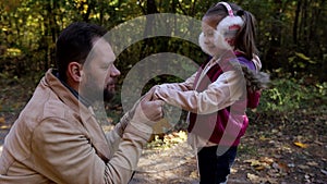 a man walks with a little girl in the autumn park, father and daughter play together