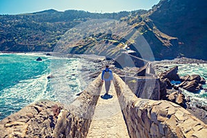 A man walks over the bridge to the island of Gaztelugatxe