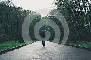 Man walks by park on rainy day