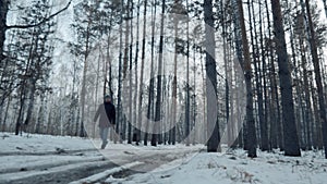 A Man Walks In A Snowy Forest, He Walks On A Dirt Road. Hicking and Travel Concept. Snowy Forest, Winter