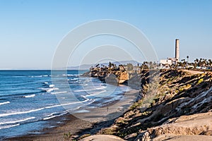 Man Walks on South Carlsbad State Beach Near Power Plant Tower