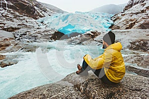 Man wanderer relaxing alone traveling at Nigardsbreen glacier in Norway