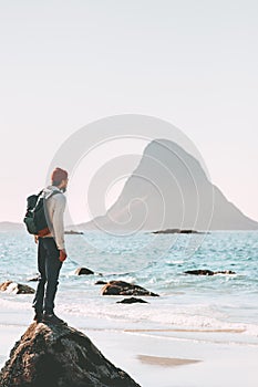 Man wandering alone enjoying sea view on beach travel in Norway