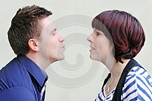 A man wants to kiss a woman who looks at him with amusement