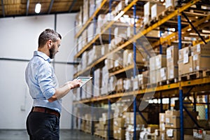 Man warehouse worker with a tablet.