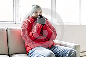 A Man With Warm Clothing Feeling The Cold Inside House on the sofa