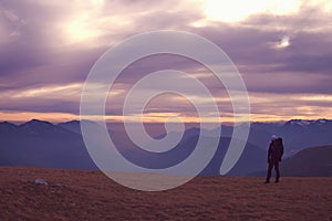 Man in warm jacket with backpack in spring rockx mountains