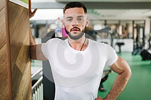 Man warm up in the gym. Handsome bearded man trains