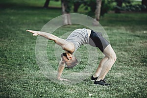 Man warming up outdoors, doing bridge exercise