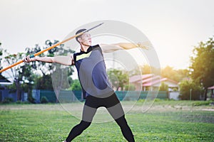 Man warming up and practicing javelin throw in yard