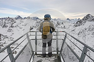 Man was standing at a viewing point in the Alps. A snowboarder stands against the background of the French Alps. Winter in french