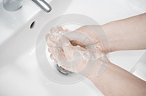 Man wash his hands deeply under a faucet with running water. Hand washing is very important to avoid the risk of contagion from