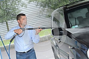 Man washes car at carwash using karcher