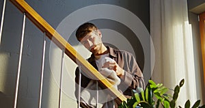 A man washes the handrails of the stairs, spraying liquid from a pulveriser