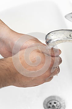 A man washes hands with soap in the bathroom. The best defense against viral infection of the crown.