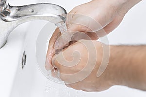 Man washes his hands in the bathroom.The best protection against corona virus infection.