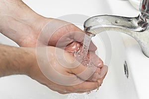 Man washes his hands in the bathroom.The best protection against corona virus infection