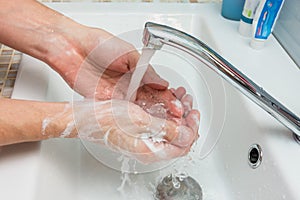 A man washes his hands from the thick suds