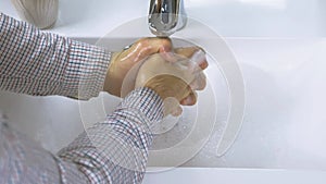 A man washes his hands to avoid contracting the widespread coronavirus.Washing hands with soap,hygiene control,close-up.