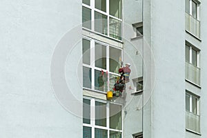 A man washes windows in a multi-storey building