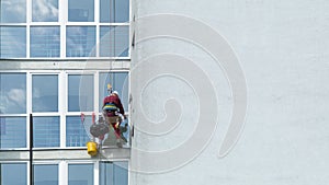 A man washes windows in a multi-storey building