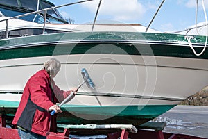 Man washing boat hull with brush