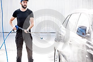 Man washing car with water gun