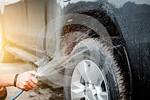 Man washing and cleaning car with spraying pressured water