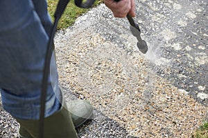 Man Washing Concrete Path With Pressure Washer