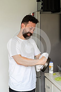 Man washing dishes in his house. Colombian having a good time at home. photo