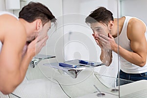 Man washing face in bathroom