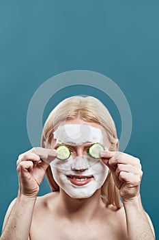 Man washing face with foam mask and cucumber slices