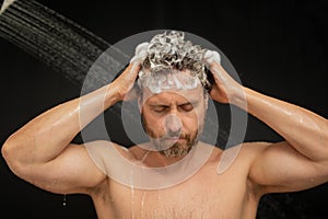 Man washing hair in bath. Guy bathing shower head in bathtub. Face in foam in shower. Bathing man taking shower. Close