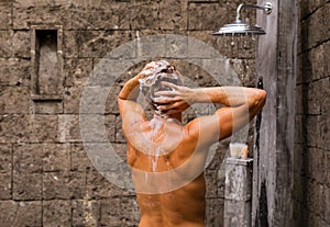 Man washing hair in outdoor shower