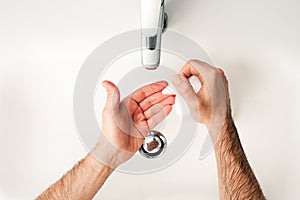 Man washing the hands in the bathroom, pushing dispenser