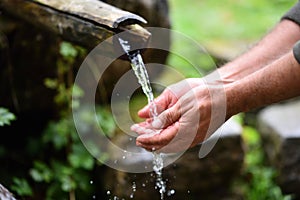 Man washing hands in fresh, cold, potable water