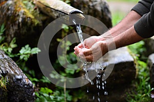 Man washing hands in fresh, cold, potable water photo