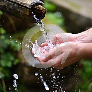 Man washing hands in fresh, cold water of mountain spri