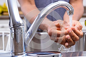 Man washing hands at kitchen sink before meal preparation