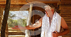 Man washing hands from shower in cottage during safari vacation 4k