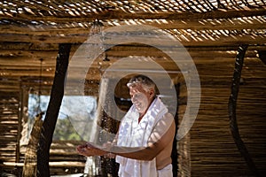 Man washing hands from shower in cottage during safari vacation